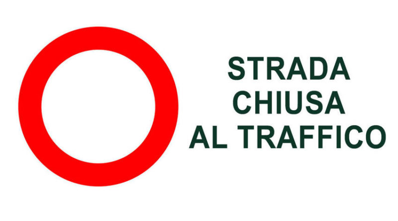 Cartello di divieto di accesso su sfondo bianco  con scritta in nero Strada Chiusa al traffico


