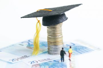 20 euro posati su un tavolo con sopra  uno sopra l'altro centesimi con alla fine appoggiato un cappello di carta nero di laurea
