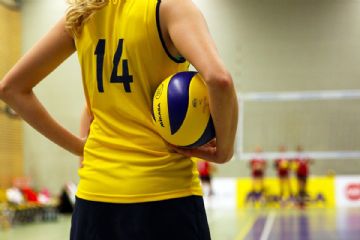 ragazza con completino giallo e nero con una palla viola e gialla